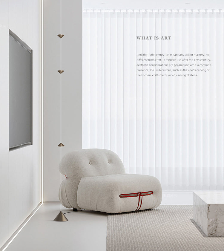 Modern white armchair with red accents in a minimalistic room.