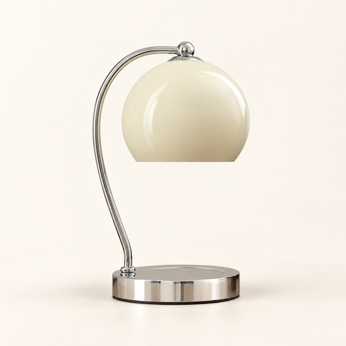 Wick table lamp with a cream dome suspended from a curved chrome arm above a round base.