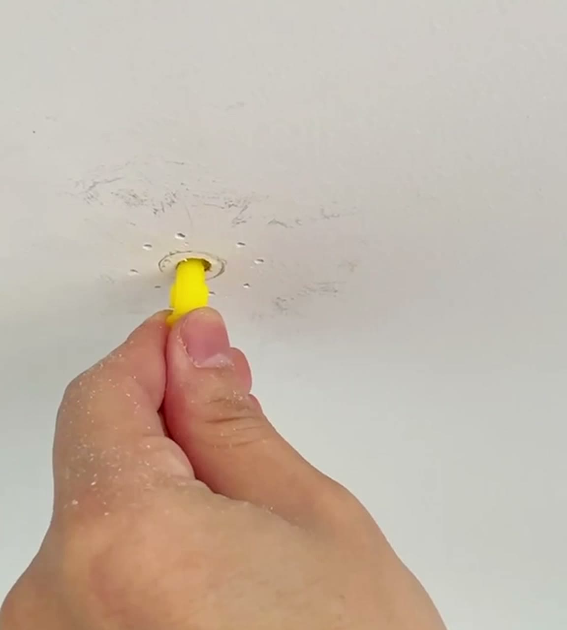 Pushing the yellow expansion anchor into the hole