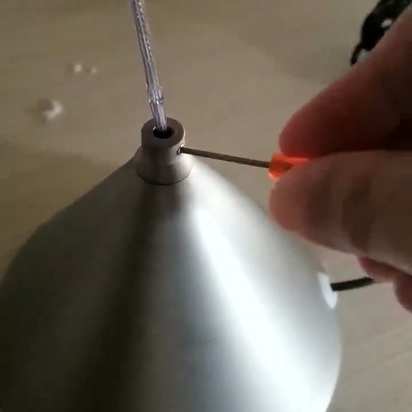 Hex key loosening the set screw at the base cone collar