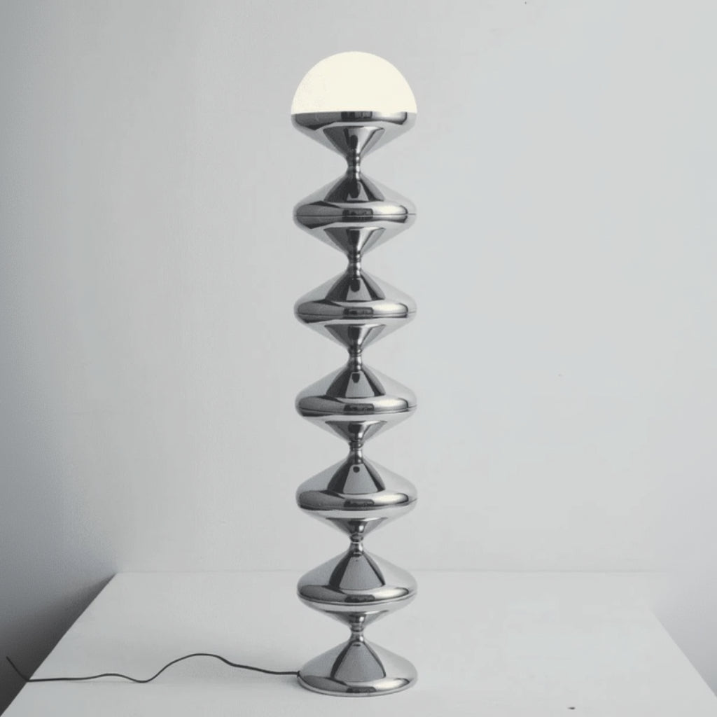 Chrome floor lamp with a white spherical light bulb on a gray background