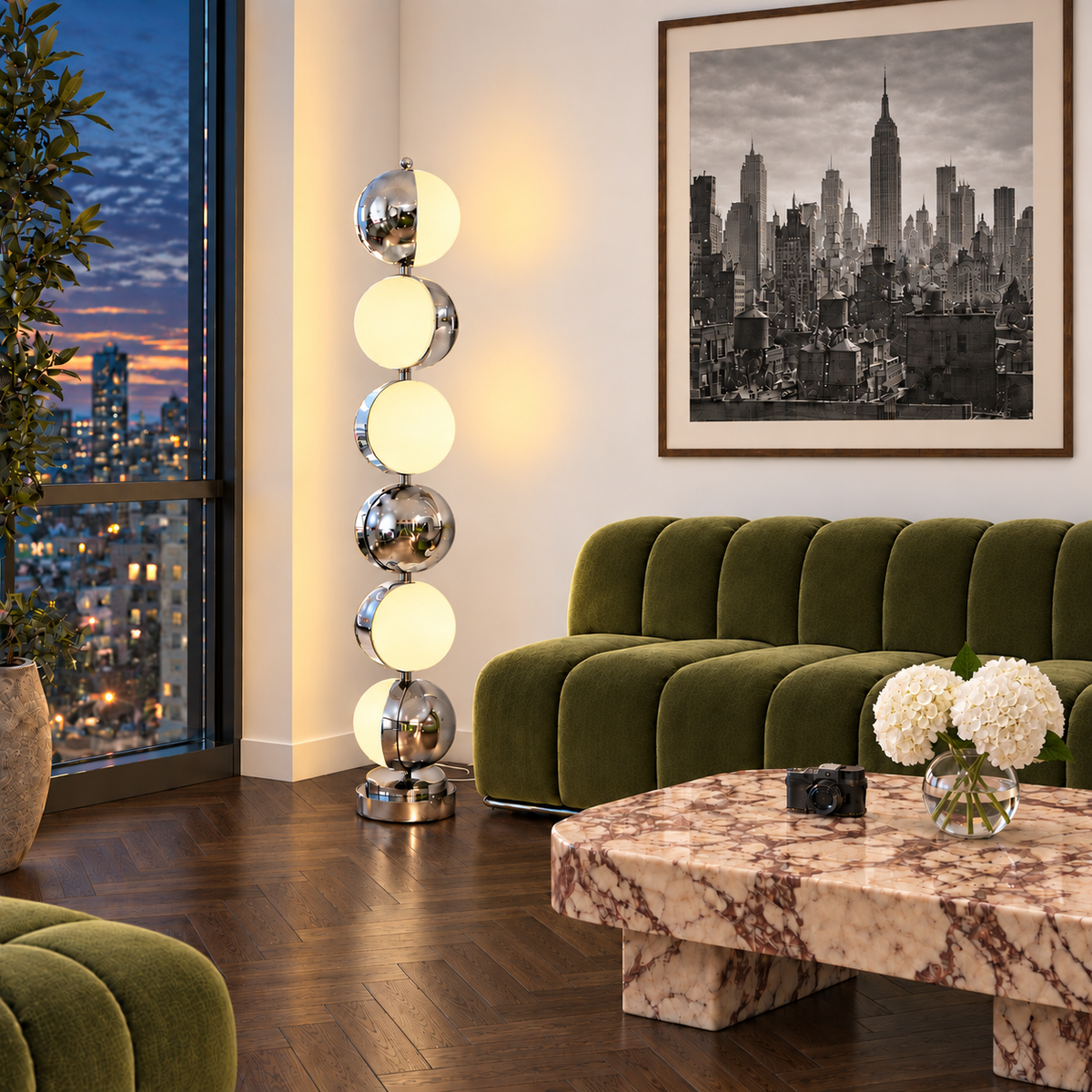 Caviar Floor Lamp glowing beside a green sofa at dusk, with dark oak parquet, a marble coffee table, white hydrangeas and a discreet white woven cord.