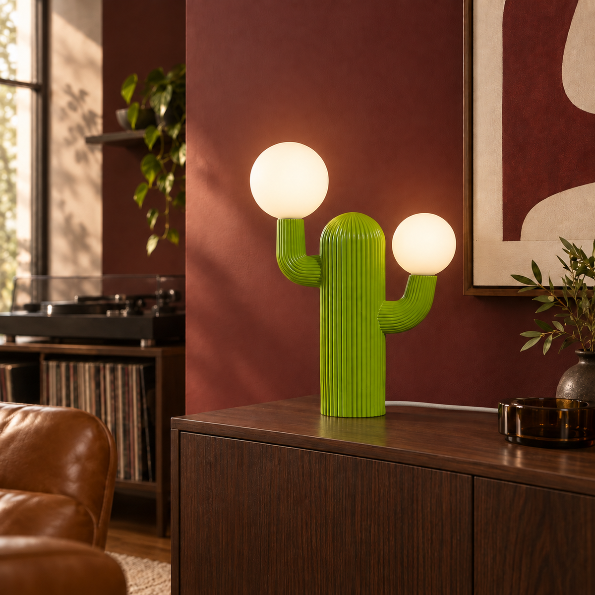 Prickly green cactus table lamp glowing warm white with a white woven fabric cord in a bordeaux room.